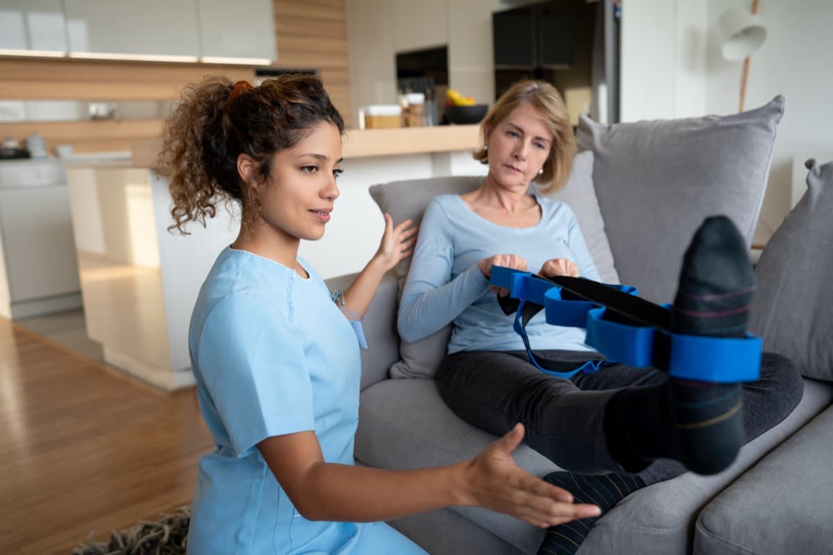 Physiotherapist guiding a patient through exercises at home